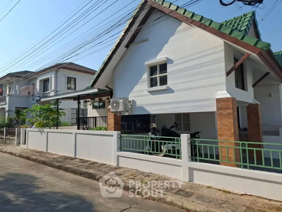 Charming suburban house with green roof and spacious driveway in a peaceful neighborhood.