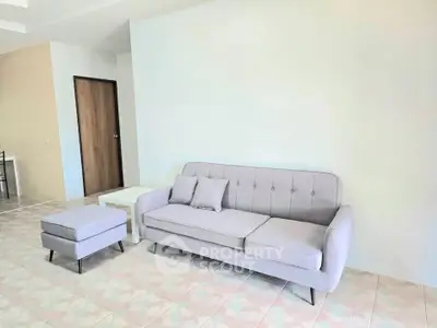 Spacious living room with modern sofa and ottoman in a bright interior