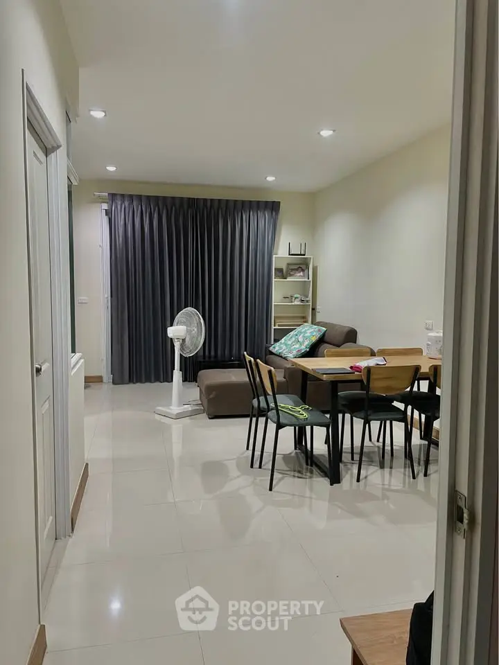 Modern living room with dining area, sleek furniture, and stylish decor in a cozy apartment setting.