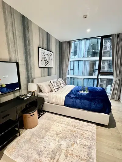 Modern bedroom with stylish decor and large window in urban apartment