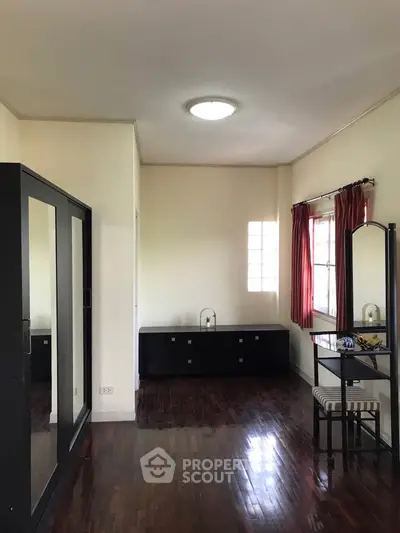 Spacious bedroom with elegant wooden flooring and stylish furniture