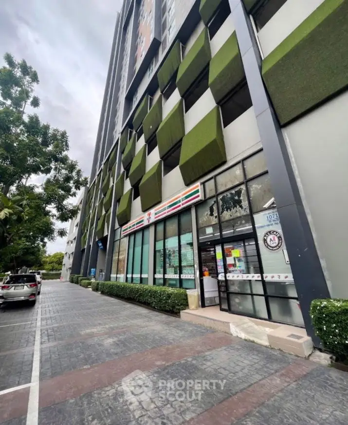 Modern building exterior with unique green facade and retail store entrance.