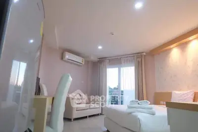 Modern bedroom with cozy seating area and balcony access in a stylish apartment.