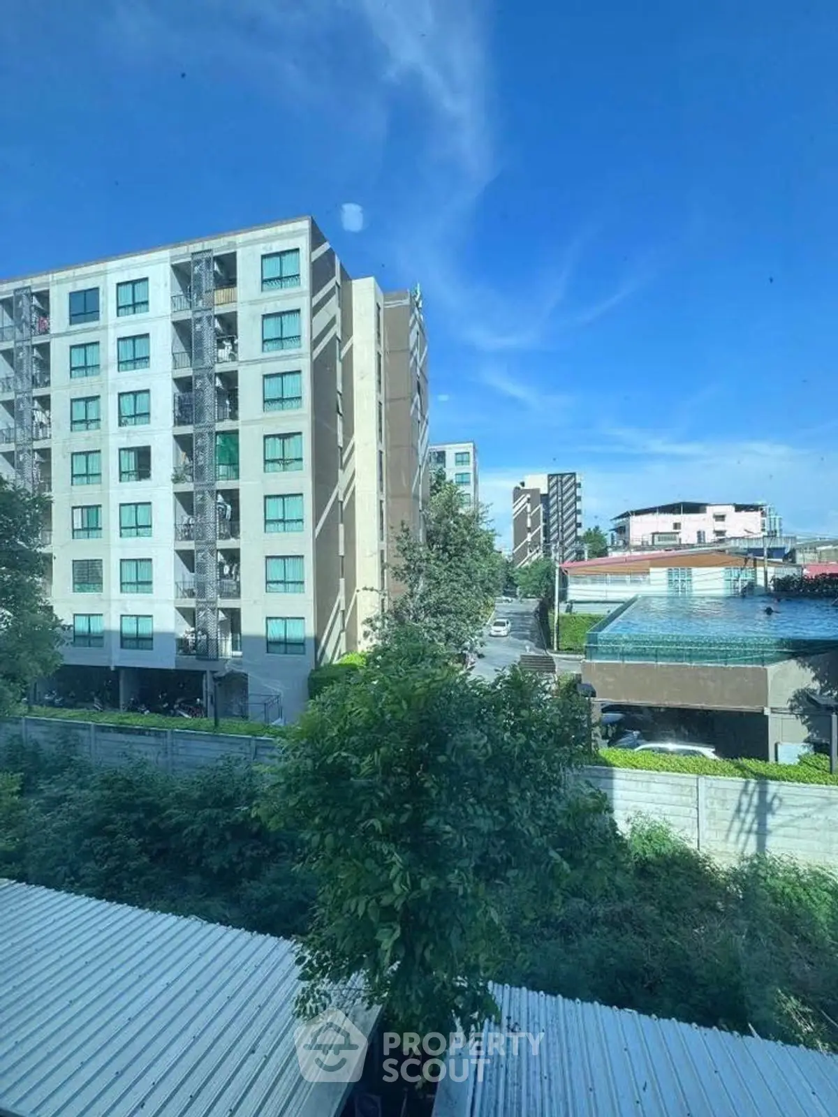 Modern apartment building with lush greenery and clear blue sky view