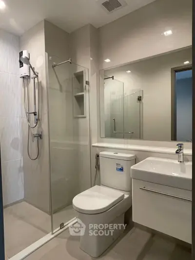 Modern bathroom with glass shower enclosure and sleek fixtures