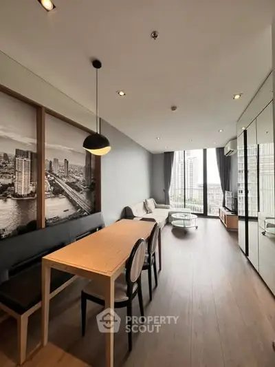 Modern living room with city view, stylish decor, and ample natural light in a high-rise apartment.