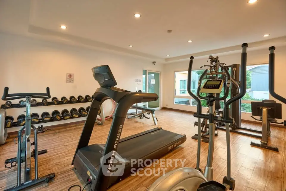 Modern gym with state-of-the-art fitness equipment and large windows for natural light.