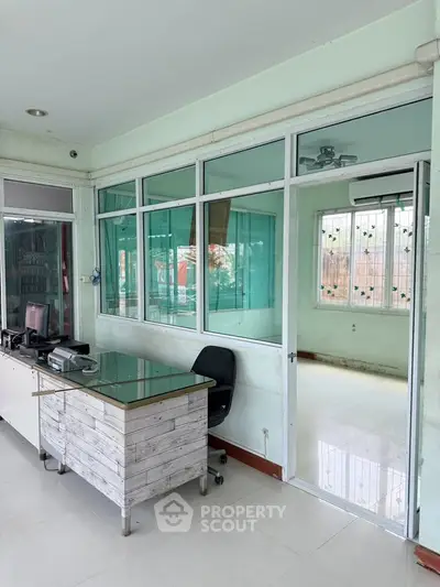 Spacious office space with glass partitions and modern desk setup