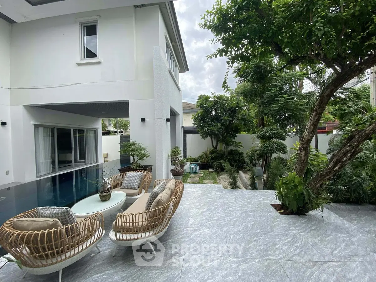 Luxurious modern home with spacious outdoor patio and lush garden, perfect for relaxation and entertaining.