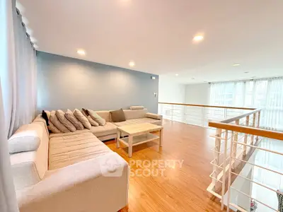 Spacious modern living room with elegant wooden flooring and cozy sectional sofa.