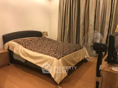 Cozy bedroom with elegant decor and wooden flooring, featuring a comfortable bed and stylish curtains.