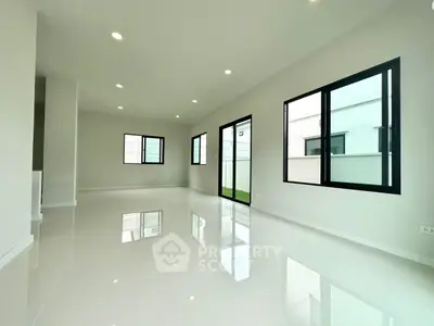 Spacious modern living room with large windows and glossy floors