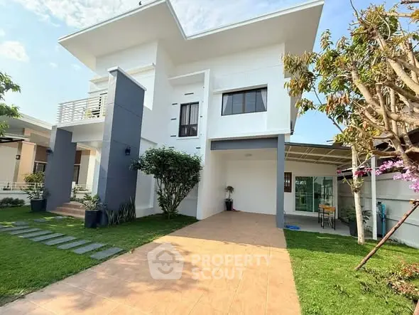 Modern two-story house with spacious driveway and lush garden, perfect for family living.