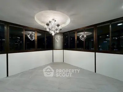 Elegant room with modern chandelier and panoramic windows, perfect for stylish living.