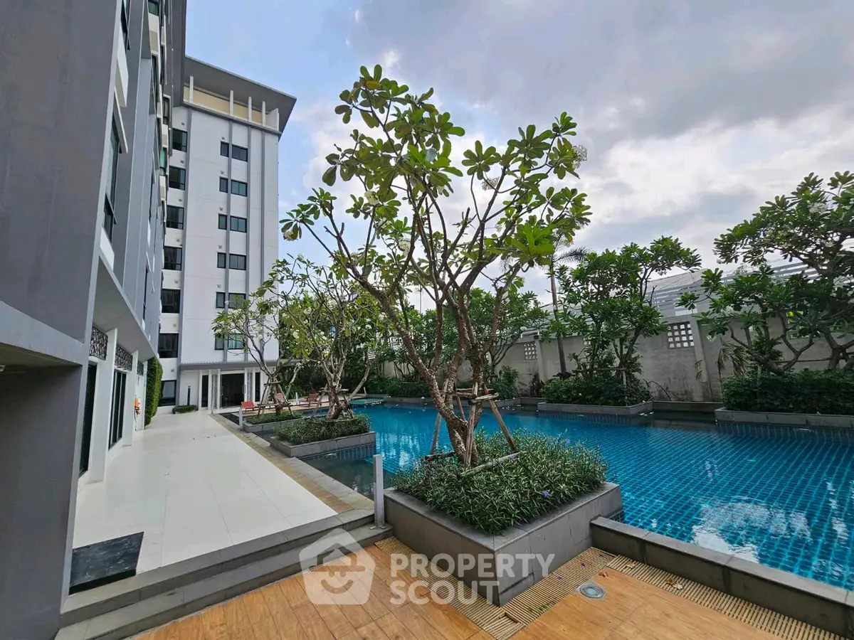 Modern condominium with poolside view and lush greenery
