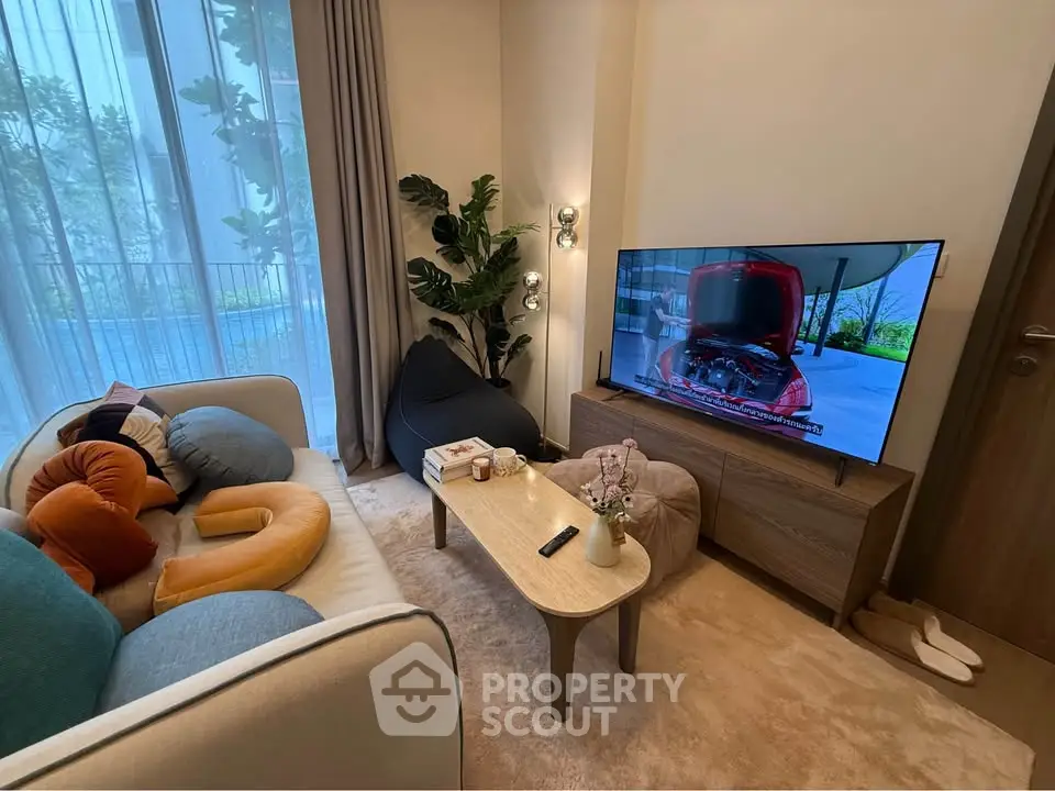 Cozy living room with modern decor, large TV, and garden view, perfect for relaxation.