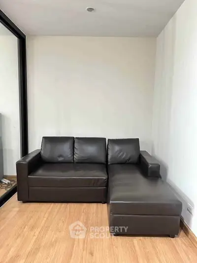 Modern living room with sleek brown leather sectional sofa and wooden flooring