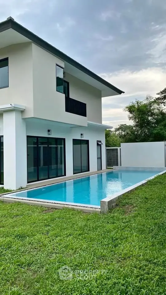 Modern two-story house with private pool and lush green lawn