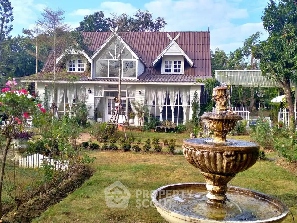 Charming countryside house with lush garden and elegant fountain, perfect for serene living.