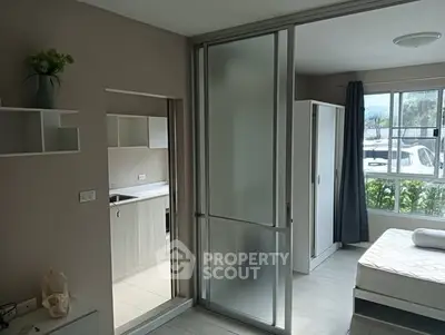 Modern studio apartment with sliding glass partition and natural light