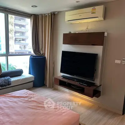 Modern bedroom with large window, air conditioning, and wall-mounted TV for ultimate comfort.