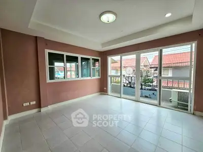 Spacious empty living room with large windows and balcony access