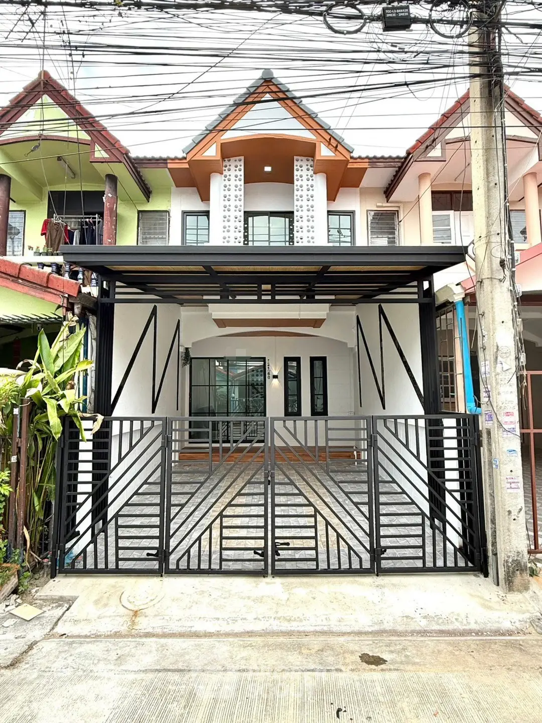 Charming townhouse with modern facade and secure gated entrance in a vibrant neighborhood.