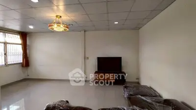 Spacious living room with modern chandelier and large window for natural light.