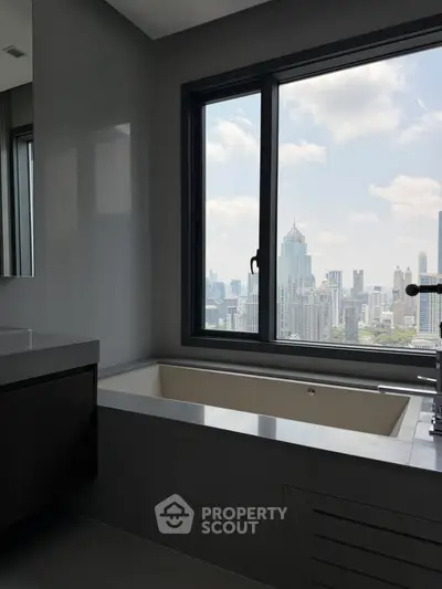 Luxurious bathroom with city skyline view from large window, featuring a modern bathtub.