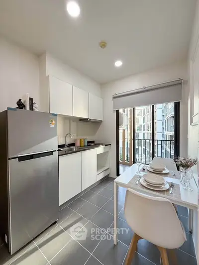 Modern kitchen with sleek appliances and dining area in a bright apartment