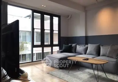 Modern living room with large windows and stylish furniture in a contemporary apartment.