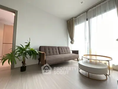 Modern living room with stylish sofa and coffee table, bright natural light from large windows.