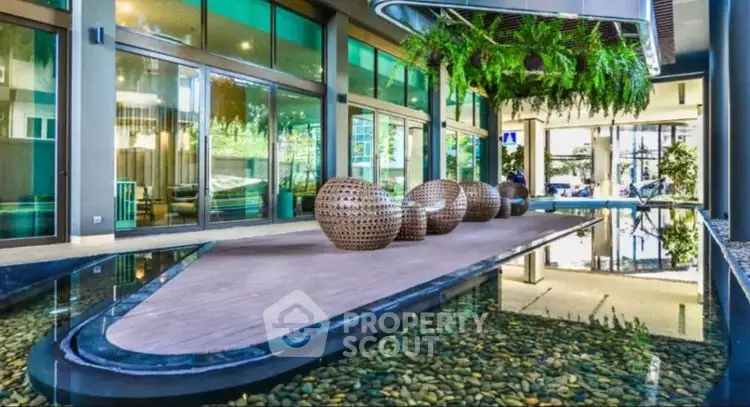 Luxurious modern building entrance with water feature and stylish seating area.