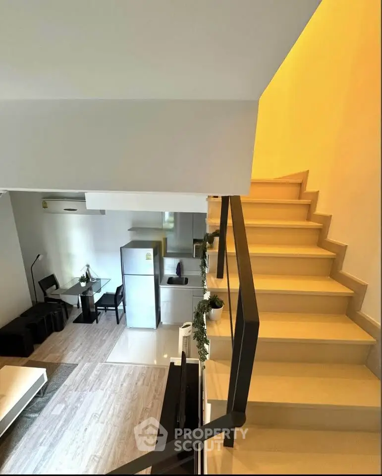 Modern duplex interior with sleek staircase and stylish living area featuring contemporary furniture and appliances.