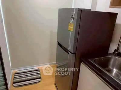 Modern kitchen with sleek refrigerator and stylish flooring