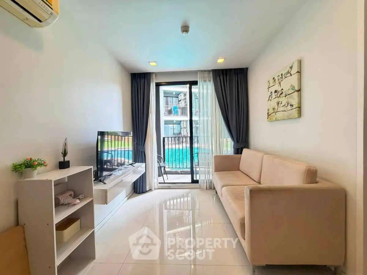 Modern living room with pool view, sleek furniture, and elegant decor in a stylish apartment.