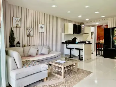 Modern open-layout living room with stylish kitchen and cozy sofa