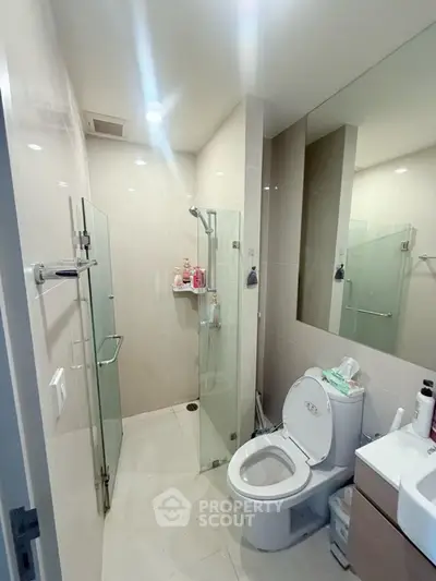 Modern bathroom with glass shower and sleek fixtures in a contemporary apartment.