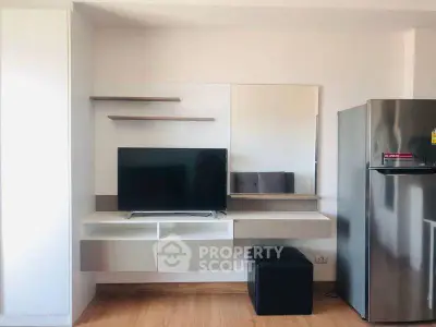 Modern living space with sleek TV unit and stainless steel fridge, perfect for contemporary urban living.