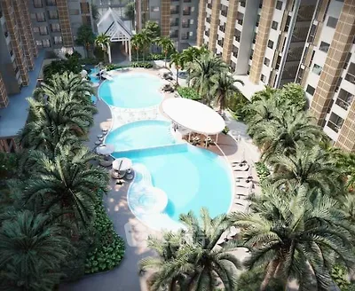 Luxurious tropical resort-style pool oasis surrounded by lush palm trees and sun loungers, nestled within a modern residential complex.