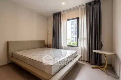 Modern bedroom with stylish bed and large window offering natural light