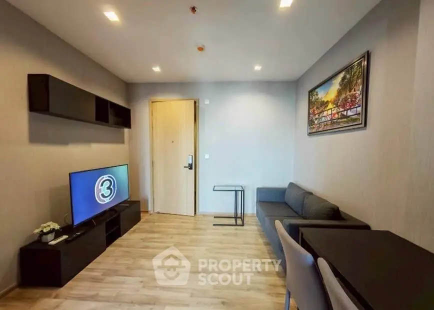 Modern living room with sleek furniture and wall-mounted TV in a stylish apartment.