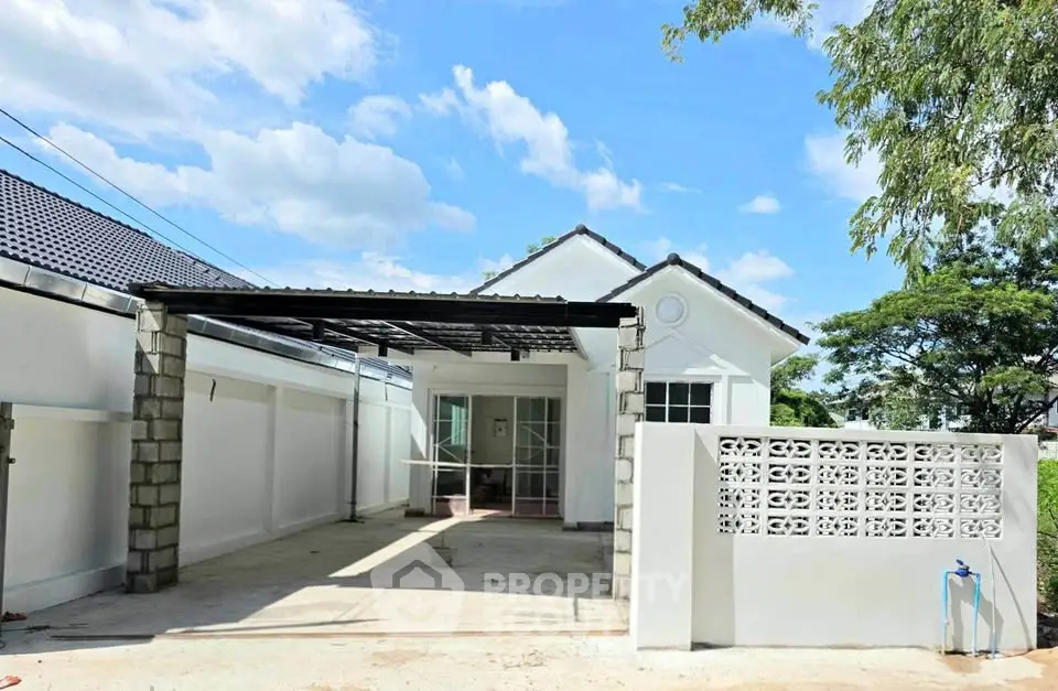 Charming white house with spacious carport and modern design in a serene neighborhood.