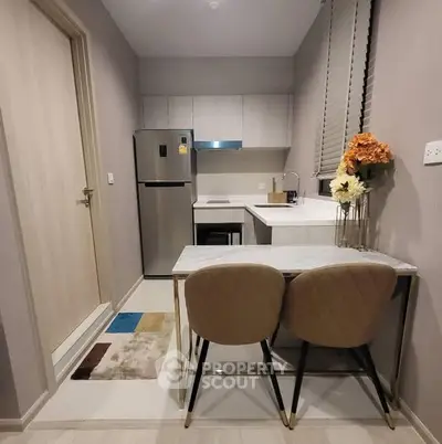 Modern compact kitchen with dining area, featuring sleek appliances and stylish decor.