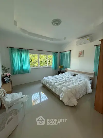 Bright and airy bedroom with large windows and modern decor, perfect for relaxation.