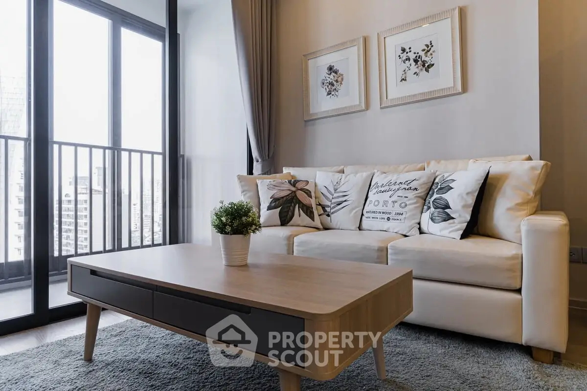 Modern living room with stylish decor and balcony view in urban apartment.