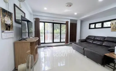 Spacious living room with large windows and modern furnishings, perfect for relaxation and entertainment.