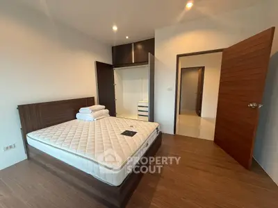 Spacious bedroom with modern wooden furniture and built-in wardrobe, perfect for comfortable living.