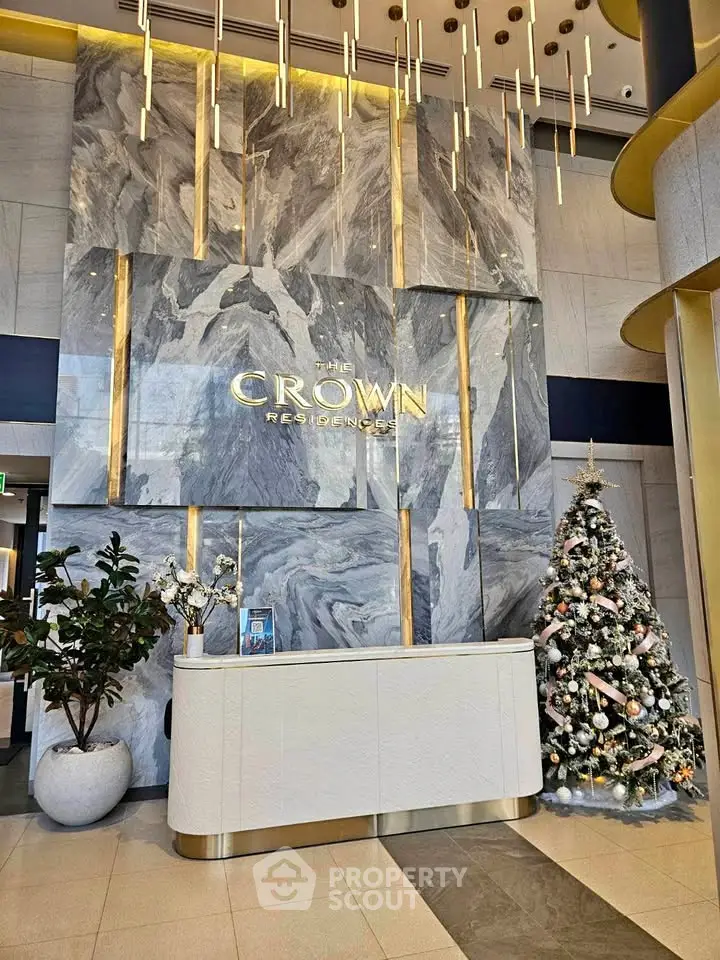 Luxurious lobby of The Crown Residences with elegant decor and festive Christmas tree.