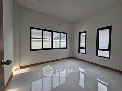 Spacious empty room with large windows and glossy tile flooring